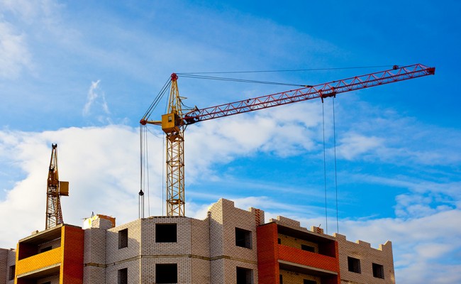 Two cranes and house construction